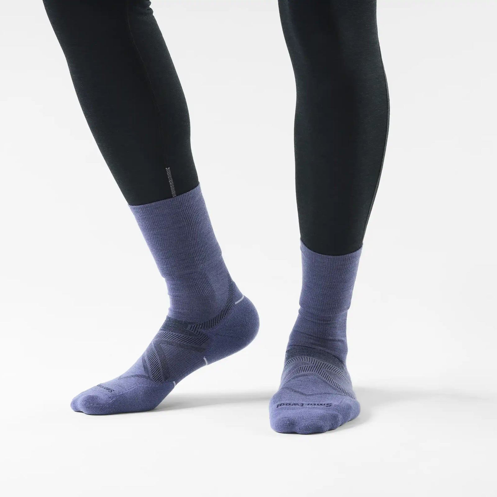 Chaussette de course Smartwool Glow pour femme en laine mérinos, coloris bleu nuit tombante, portée avec des collants de course
