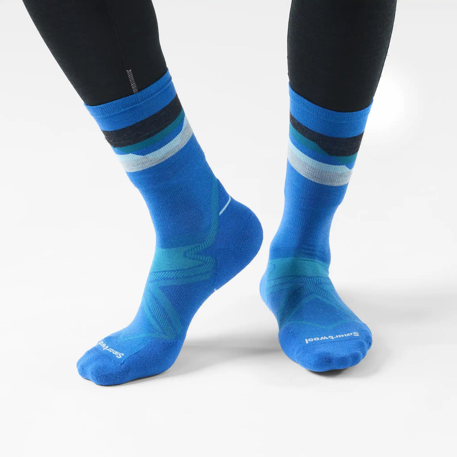 Chaussette de course Smartwool Horizons pour homme en laine mérinos, coloris bleu lagon avec motif chaîne de montagnes, portée avec des collants de course