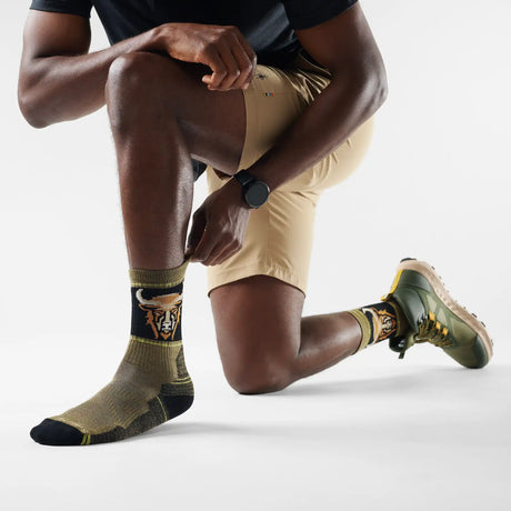 Chaussette de randonnée Smartwool Bison pour homme en laine mérinos, coloris mousse d'hiver avec motif tête de bison, portée avec des souliers de randonnée