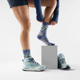 Chaussette de randonnée Smartwool Otter Float pour femme en laine mérinos, coloris bleu nuit tombante avec motif loutre, portée avec des bottes de randonnée